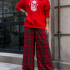 Modelo luciendo la Sudadera Corazón Esqueleto Roja con capucha y estampado de una mano esquelética sujetando un corazón anatómico.