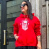 Modelo luciendo la Sudadera Corazón Esqueleto Roja con capucha y estampado de una mano esquelética sujetando un corazón anatómico.