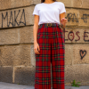 Modelo vistiendo el Pantalón Escocés Rojo de pierna ancha con estampado tartán rojo y cintura alta.