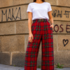 Pantalón Escocés Rojo para mujer con estampado de cuadros tartán, corte palazzo y cinturón de hebilla redonda, combinado con camiseta blanca.
