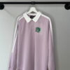 polo color lila con líneas blancas y cuello blanco. Un estampado en terciopelo verde de un leopardo rugiendo es un complemento estilo universitario americano perfecto