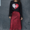 falda de corte midi, estrecha pero no ajustada de estampado animal print rojo combinada con camiseta de manga larga todo de la marca pepa rodriguez