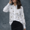 Camisa blanca de manga larga con bordados de corazones de lentejuelas combinada con falda negra, look elegante y femenino.