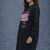 vestido negro con mangas de lentejuela y corte estilo sudadera más fina y larga, cuenta con un estampado de que el alma no vibra por cualquiera