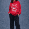 Sudadera roja de mujer con capucha y estampado gráfico blanco en la parte frontal, corte recto y manga larga.