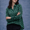 Camisa verde de mujer con estampado animal print, manga larga y corte recto, combinada con pantalón negro.