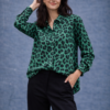 Camisa verde de mujer con estampado animal print, manga larga y corte recto, combinada con pantalón negro.