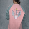 Sudadera bicolor rosa y verde con diseño geométrico y estampado central, combinada con cualquier outfit