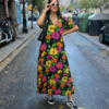 vestido largo de tela ligera con flores de varios colores vivos y fondo negro ideal para verano con escote en pico