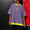 Mujer luciendo la Camiseta Neon Stripes de rayas azul marino y rosa con detalles en amarillo neón.