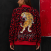 Parte trasera de chaqueta bomber roja animal print con ilustración de tigre y detalle gráfico decorativo.