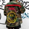 Parte trasera de sobrecamisa militar mujer con flecos decorativos y diseño gráfico personalizado.