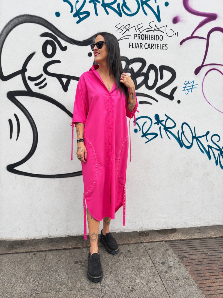 Vestido camisero fucsia oversize para mujer con corte midi, cierre frontal y detalles de tachas decorativas.