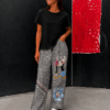 Modelo vistiendo el Pantalón Popeye de corte palazzo con estampado Príncipe de Gales e ilustraciones inspiradas en Popeye.