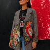 Mujer vistiendo la Blazer Guacamayo con estampado floral multicolor y gran guacamayo tropical sobre tejido de cuadro príncipe de Gales.