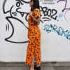 Vestido Wild Neon naranja con estampado animal print y abertura lateral, vista de perfil mostrando el corte y la caída del tejido.