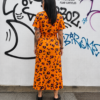 Vestido salvaje naranja con estampado animal print, vista trasera mostrando el diseño completo y el cinturón ajustable.