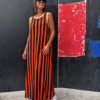 Vestido maxi de rayas naranja y azul marino combinado con zapatillas blancas, ideal para un estilo casual y moderno, mas lateral