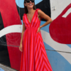Vestido Flamingo de corte largo y fluido con diseño de rayas vibrantes en tonos rosa y rojo.