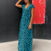 Mujer luciendo el Vestido Blue Leopard, un vestido maxi azul turquesa con estampado animal print y escote en V.