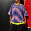 Camiseta oversize de rayas horizontales en tonos azul y rosa con acabado moderno y urbano.