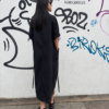 Vestido largo negro de diseño fluido y minimalista con tirantes anchos y detalles estructurados en el bajo parte trasera